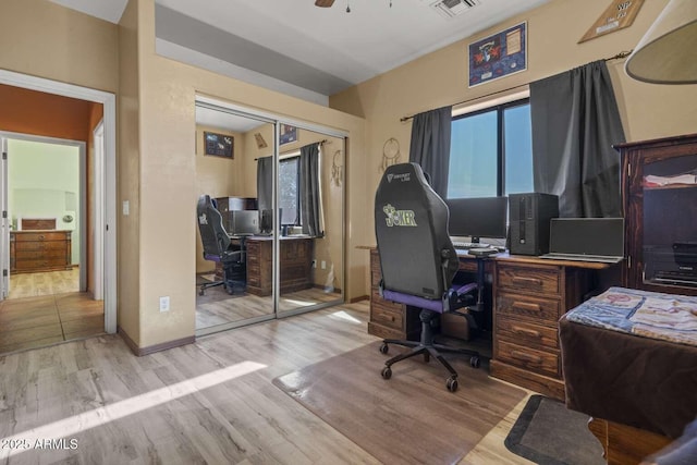 office area featuring light wood-style floors, baseboards, visible vents, and a ceiling fan