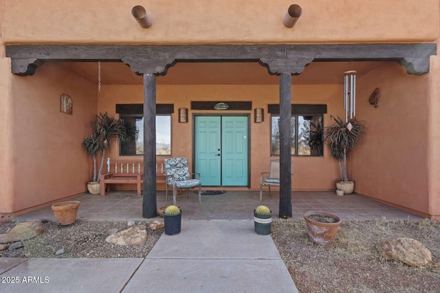 doorway to property featuring stucco siding