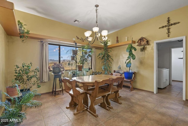 dining space with washer / dryer, baseboards, visible vents, and a notable chandelier