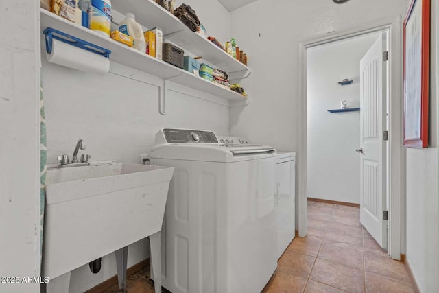 washroom with washer and clothes dryer, light tile patterned floors, a sink, laundry area, and baseboards