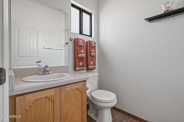 bathroom featuring a textured wall, vanity, toilet, and tile patterned floors