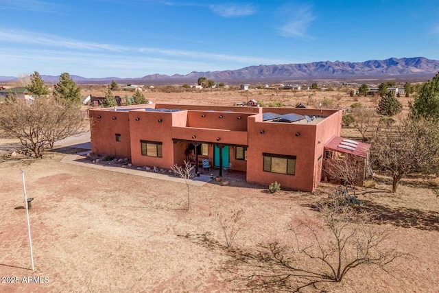 adobe home with a mountain view and stucco siding