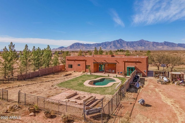 exterior space featuring a fenced in pool, a fenced backyard, a mountain view, and a patio