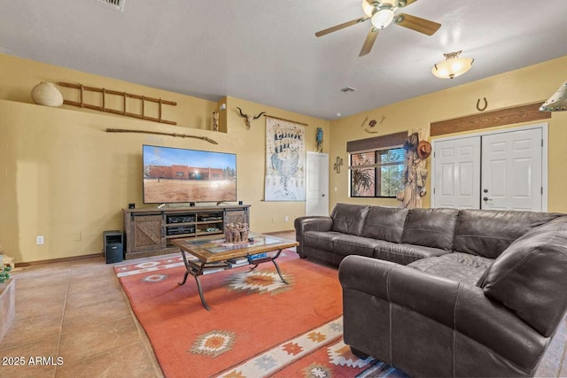 tiled living room with a ceiling fan, visible vents, and baseboards