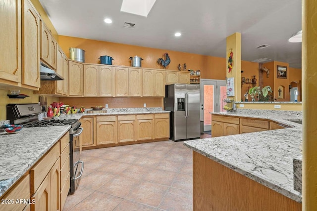 kitchen featuring light stone countertops, under cabinet range hood, visible vents, and stainless steel appliances