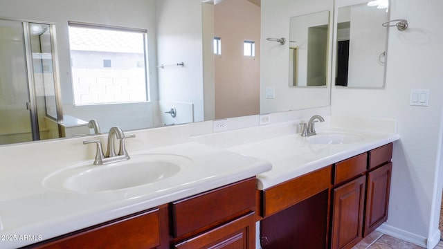 bathroom featuring a stall shower, a sink, and double vanity