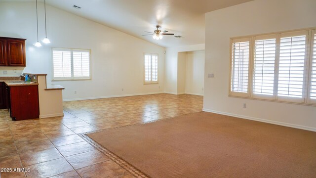 unfurnished living room featuring light tile patterned floors, visible vents, ceiling fan, a sink, and baseboards