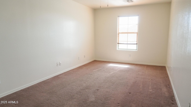 spare room with visible vents, baseboards, and carpet flooring