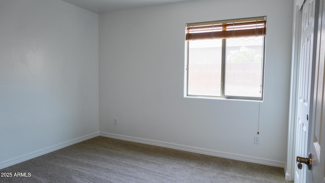 carpeted spare room featuring baseboards