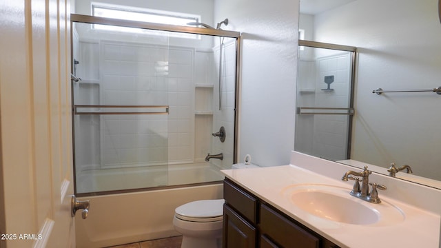 bathroom featuring combined bath / shower with glass door, vanity, and toilet