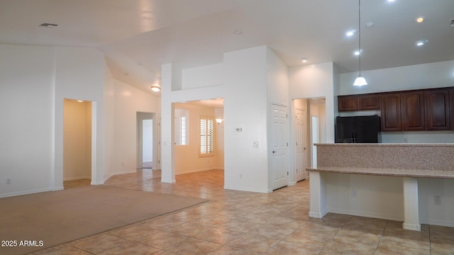 kitchen featuring high vaulted ceiling, freestanding refrigerator, decorative light fixtures, and dark brown cabinetry