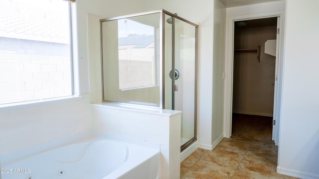 bathroom with tile patterned flooring, a garden tub, a shower stall, and a spacious closet