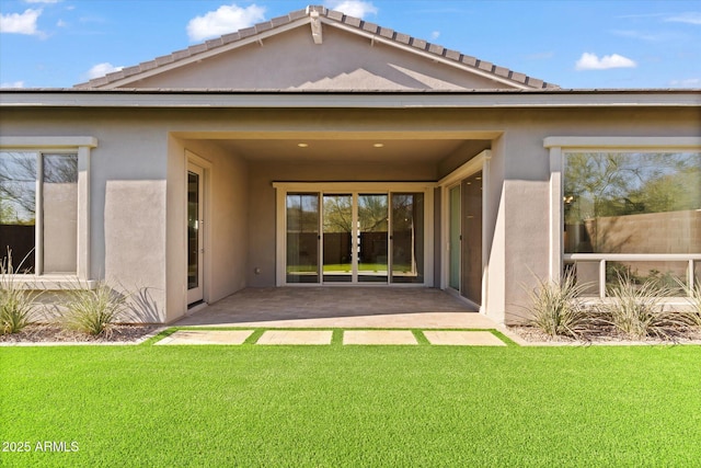 back of property featuring a lawn and a patio area