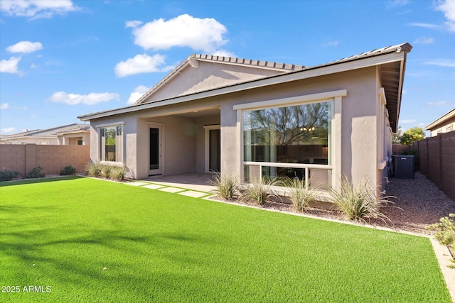 back of property with a lawn, a patio, and central AC unit