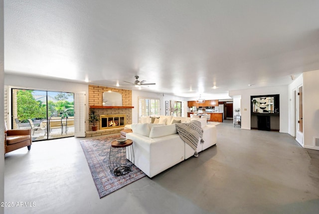 1106 N Villa Nueva Dr, Litchfield Park, AZ 85340 - living area featuring finished concrete floors, plenty of natural light, a brick fireplace, and a ceiling fan