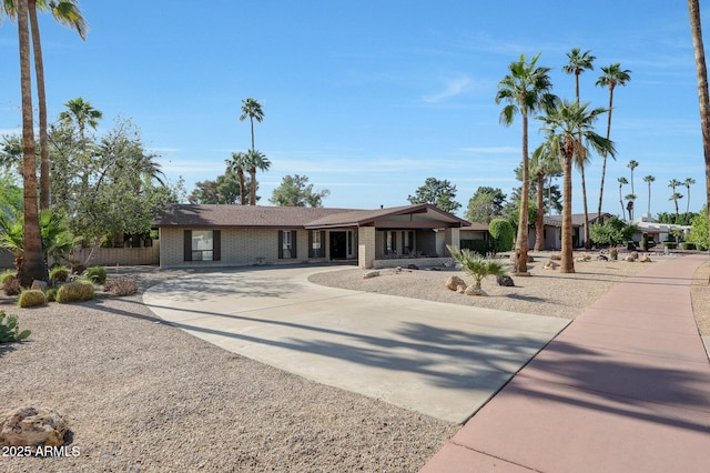 1106 N Villa Nueva Dr, Litchfield Park, AZ 85340 - view of front of home with curved driveway, brick siding, and fence