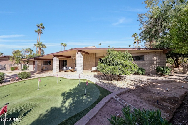 1106 N Villa Nueva Dr, Litchfield Park, AZ 85340 - view of front facade featuring a putting green, a patio, and brick siding