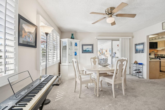 carpeted dining space featuring a textured ceiling and ceiling fan