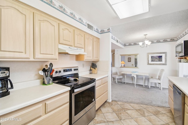 kitchen featuring light brown cabinetry, stainless steel appliances, a chandelier, hanging light fixtures, and light tile patterned flooring