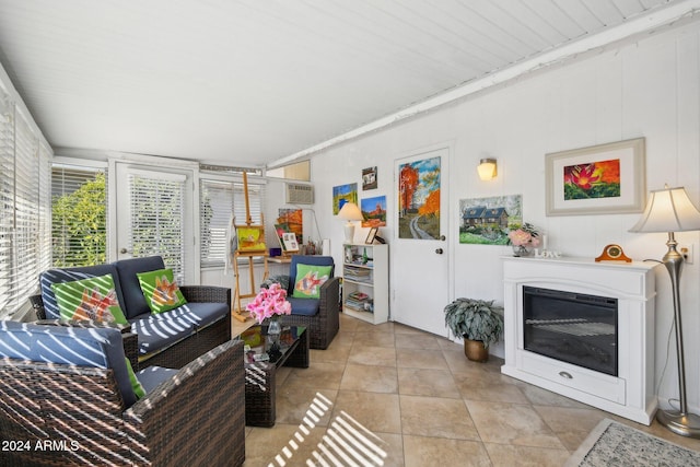 living room featuring light tile patterned floors and an AC wall unit