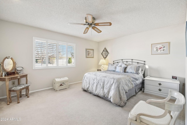 bedroom with ceiling fan, light carpet, and a textured ceiling