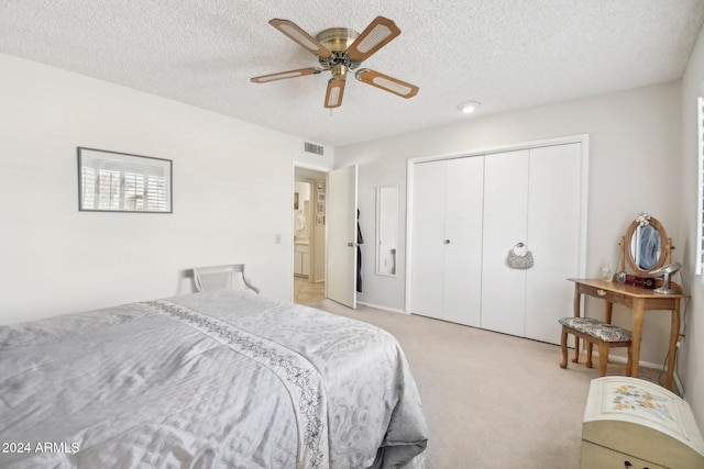 bedroom featuring light carpet, a textured ceiling, a closet, and ceiling fan