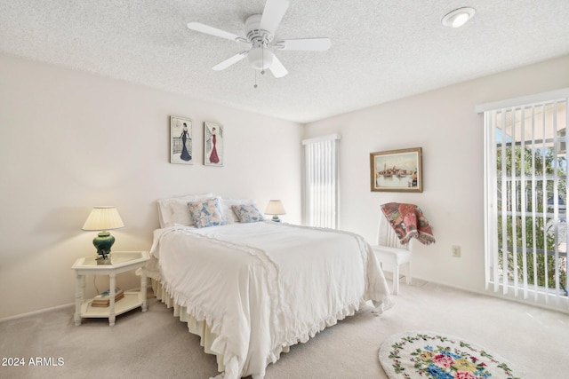 carpeted bedroom with a textured ceiling and ceiling fan