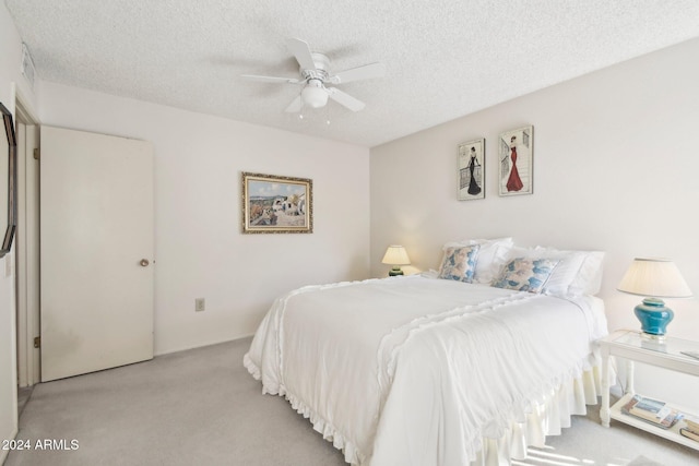 carpeted bedroom featuring a textured ceiling and ceiling fan