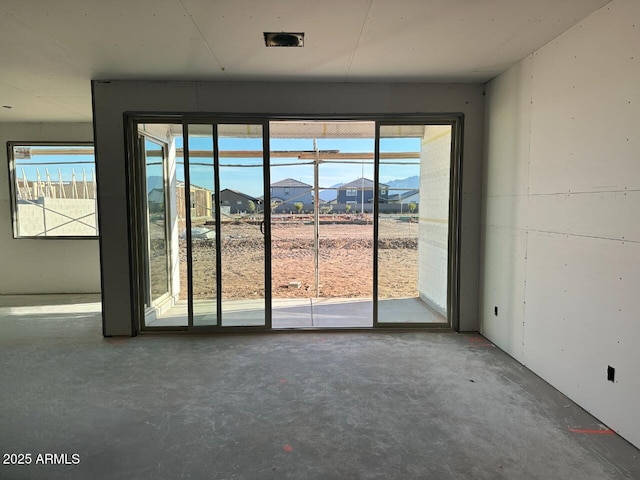 doorway to outside featuring a residential view and concrete flooring