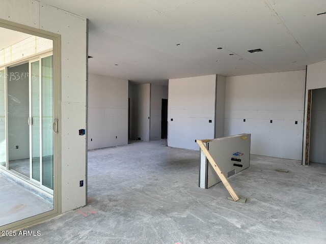 unfurnished room with unfinished concrete flooring