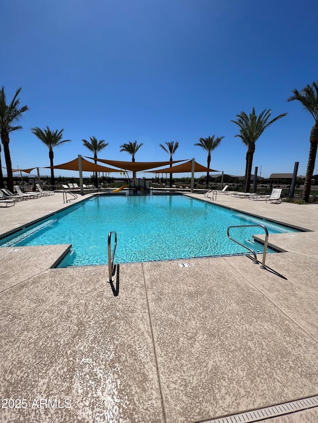 pool with a patio area and fence