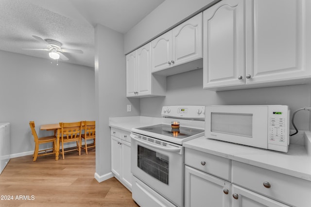 kitchen featuring white appliances, white cabinets, ceiling fan, light wood-type flooring, and a textured ceiling