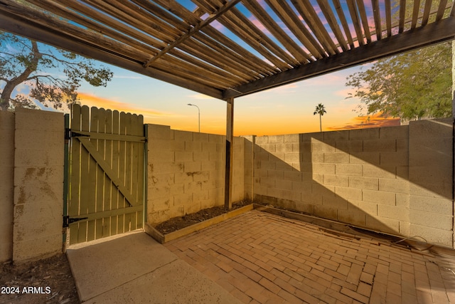 patio terrace at dusk featuring a pergola