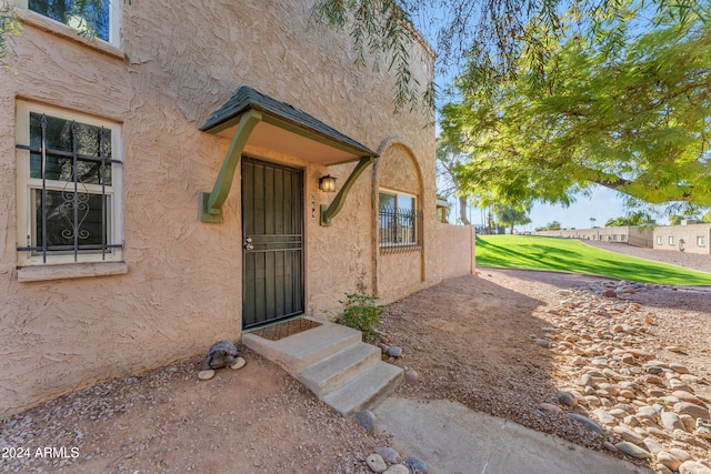 property entrance with a lawn