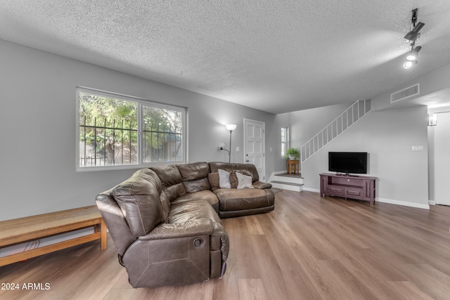 living room with hardwood / wood-style flooring and a textured ceiling