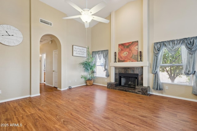 1241 W Lobster Trap Dr, Gilbert, AZ 85233 - unfurnished living room with high vaulted ceiling, a fireplace, arched walkways, wood finished floors, and a ceiling fan