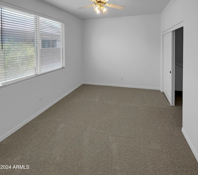 carpeted spare room with ceiling fan