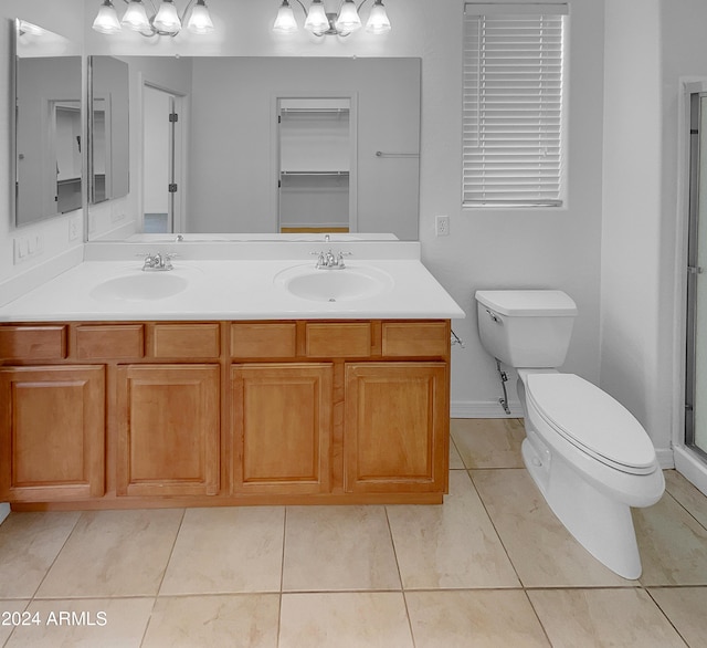 bathroom with tile patterned floors, vanity, toilet, and a shower with shower door