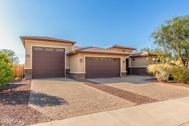 18108 W Cassia Way, Goodyear, AZ 85338 - prairie-style house featuring stucco siding, stone siding, decorative driveway, and an attached garage