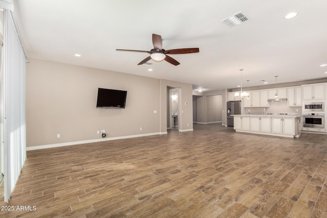 18108 W Cassia Way, Goodyear, AZ 85338 - unfurnished living room featuring a ceiling fan, recessed lighting, and light wood-type flooring