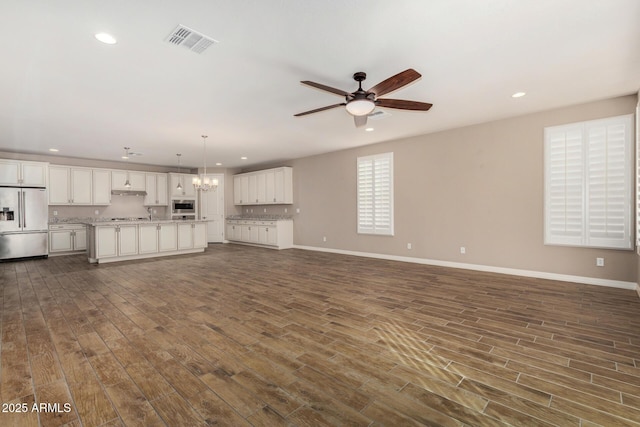 18108 W Cassia Way, Goodyear, AZ 85338 - unfurnished living room featuring ceiling fan, recessed lighting, dark wood-style floors, and a chandelier
