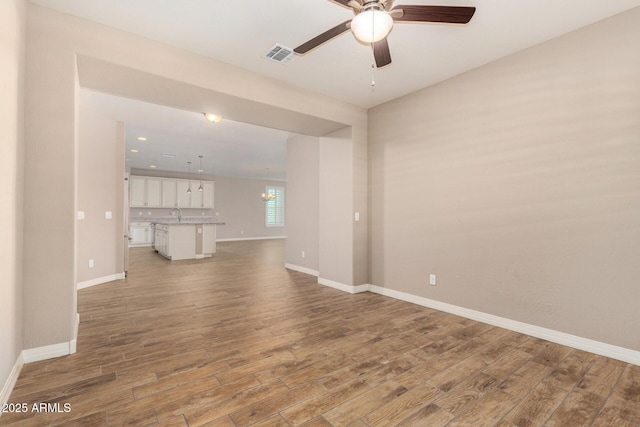 18108 W Cassia Way, Goodyear, AZ 85338 - unfurnished living room featuring ceiling fan and light wood-style flooring