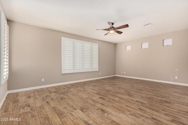 18108 W Cassia Way, Goodyear, AZ 85338 - empty room with ceiling fan, wood finished floors, and healthy amount of natural light