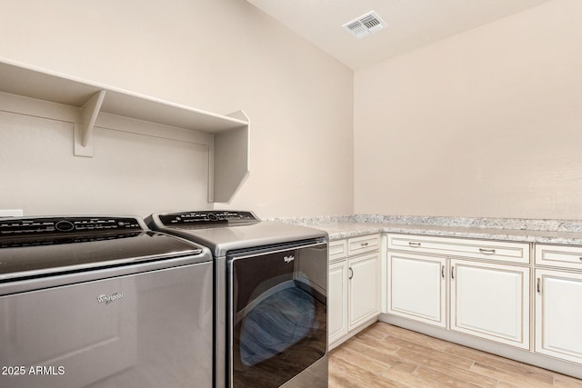 18108 W Cassia Way, Goodyear, AZ 85338 - washroom featuring washer and clothes dryer, cabinet space, and light wood-type flooring