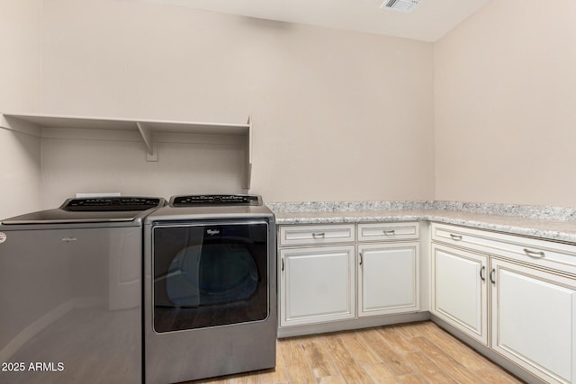 18108 W Cassia Way, Goodyear, AZ 85338 - washroom with separate washer and dryer, cabinet space, and light wood-style floors