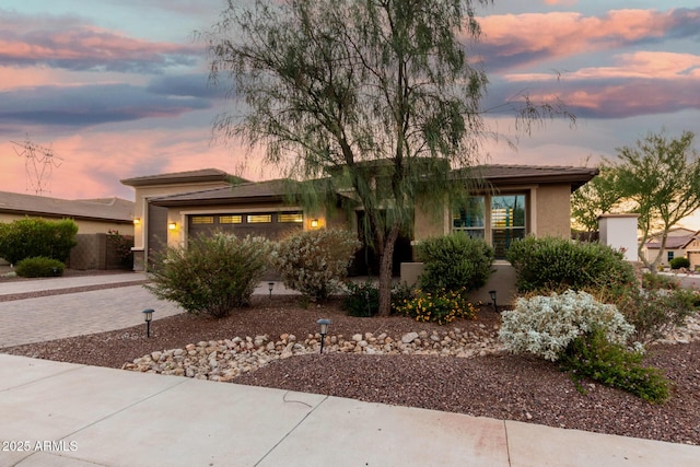 18108 W Cassia Way, Goodyear, AZ 85338 - view of front of home featuring stucco siding, a garage, and decorative driveway