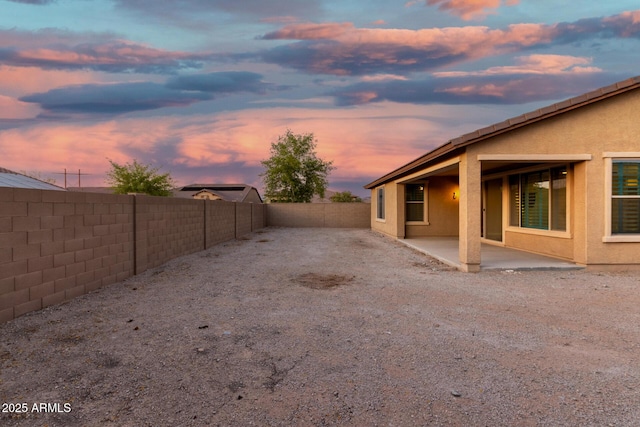 18108 W Cassia Way, Goodyear, AZ 85338 - yard at dusk with a fenced backyard and a patio