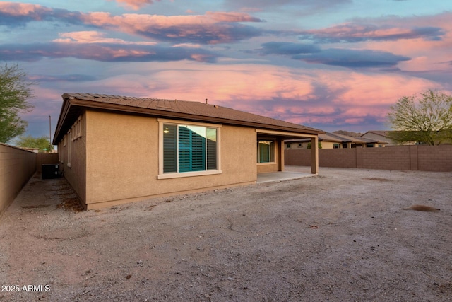 18108 W Cassia Way, Goodyear, AZ 85338 - back of house at dusk featuring stucco siding, a patio area, and a fenced backyard