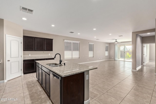 kitchen with stainless steel dishwasher, dark brown cabinetry, sink, and a center island with sink