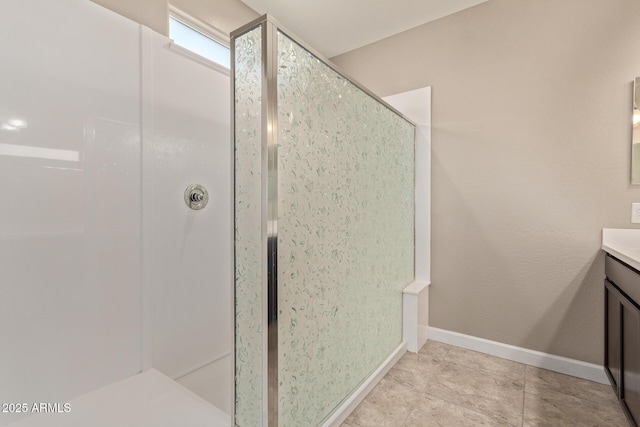 bathroom with tile patterned flooring, vanity, and walk in shower